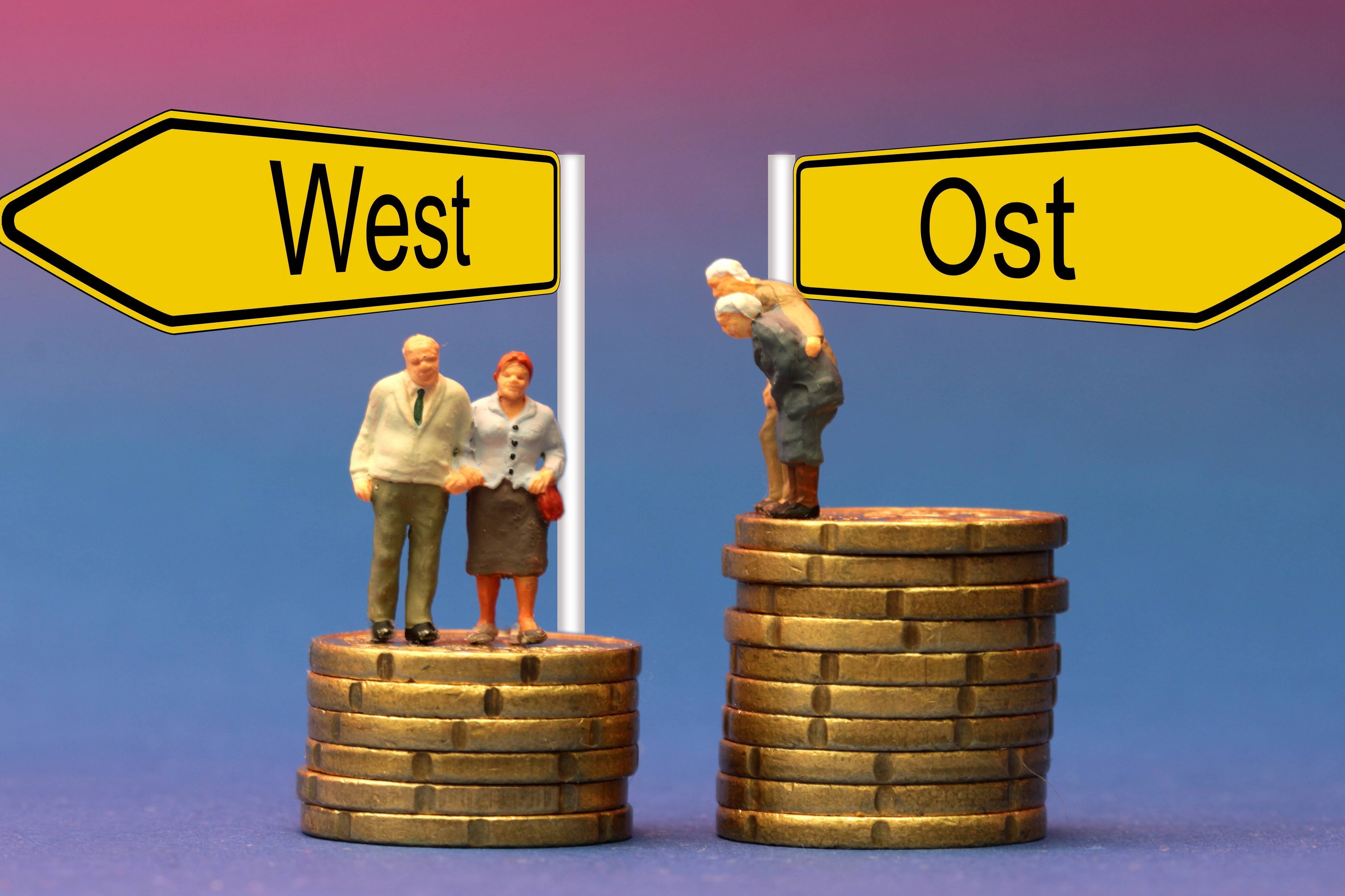 Symbolbild Rentenanpassung in Ost und West: Senioren stehen auf unterschiedlich hohen Münzstapeln 