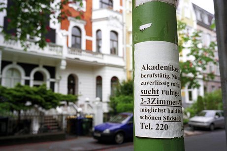 Wohnungssuche Zettel mit einem Wohnungsgesuch und Abreißzetteln mit der Telefonnummer des Interessenten an einem Laternenmast