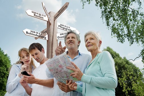 VdK als Wegweiser im Sozialrecht Ein jüngeres und ein älteres Pärchen suchen mit einer Karte nach etwas, hinter ihnen ein Wegweiser, auf dem verschiedene Begriffe aus dem Sozialrecht stehen.