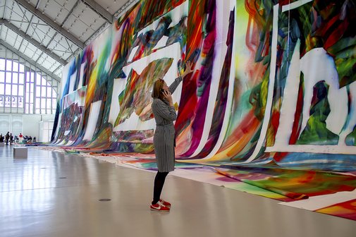 Bei Anruf Kultur in den Hamburger Deichtorhallen Stefanie Reimers steht in der Ausstellungshalle, betrachtet ein großformatiges Bild und spricht ins Telefon.