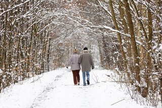 Älteres Paar geht im Schnee spazieren