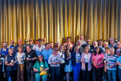 Aktionsstart Alles geht zusammen Gruppenfoto: Ehrenamtlich Engagierte auf der Bühne vor der Leinwand im Kino Delphi Lux in Berlin.