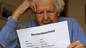 Symbolfoto: Eine Seniorin liest ihren Rentenbescheid
