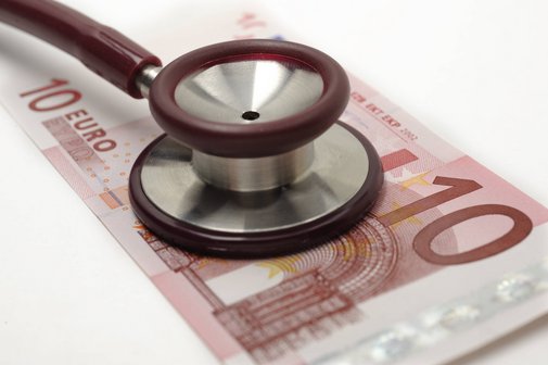 Steigende Kosten bei den Krankenkassenbeiträgen Ein Zehn-Euro-Schein, auf dem ein Stethoskop liegt