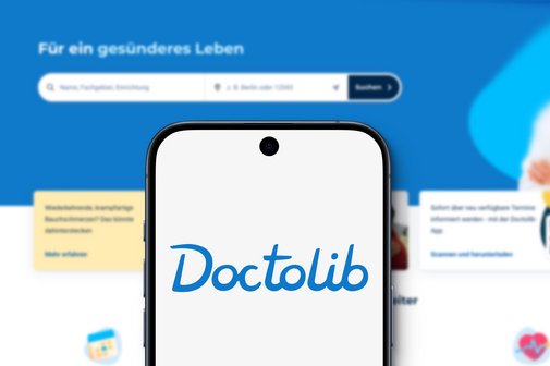 Online-Terminportal Doctolib Ein Screenshot der Website von Doctolib, davor ein Smartphone, auf dem der Doctolib-Schriftzug zu sehen ist.