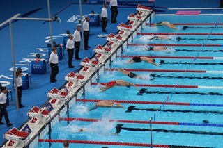 Blick ins Schwimmbecken beim Wettkampf der Schwimmer in der Rückenlage