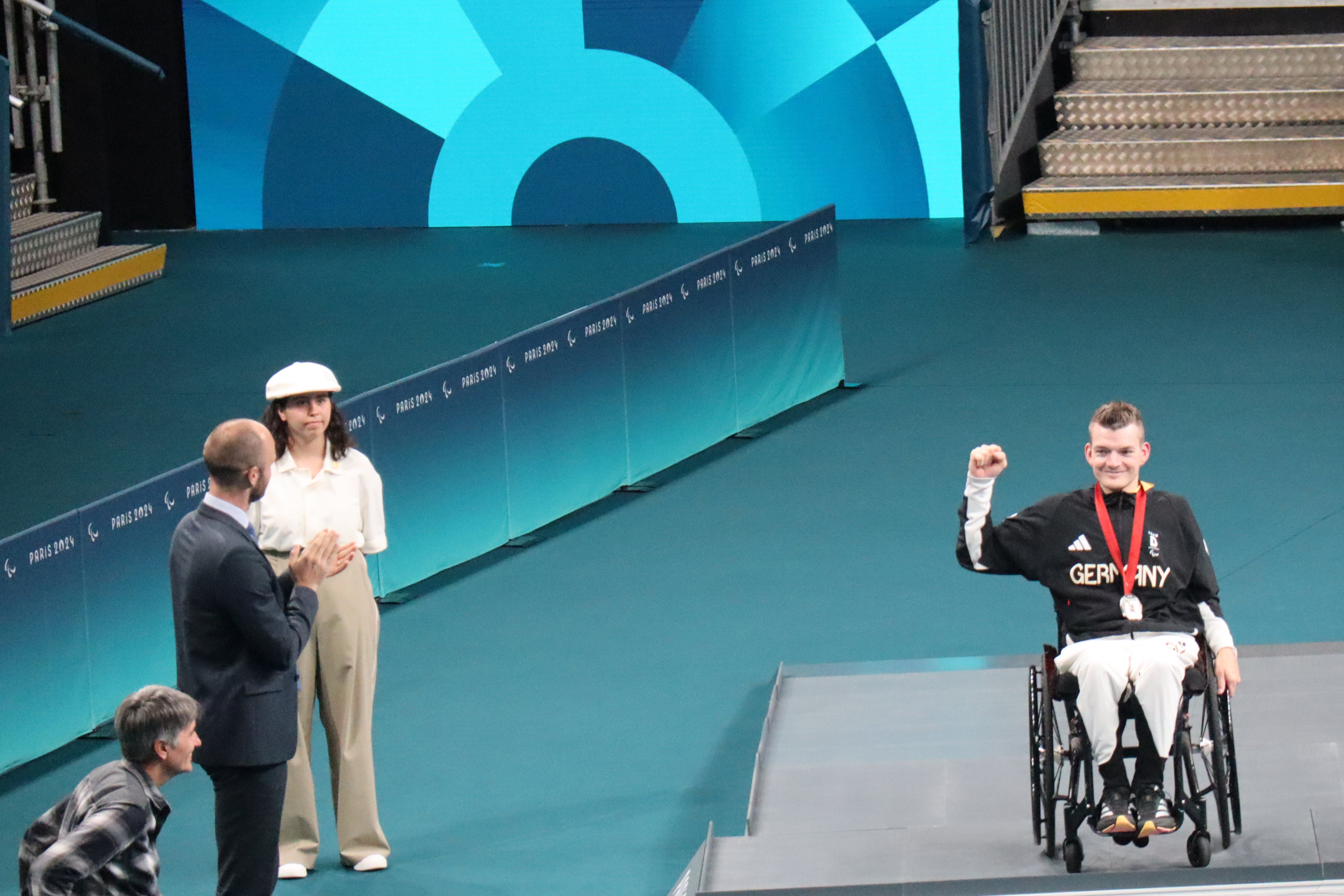 Thomas Schmidberger (rechts im Rollstuhl) hält seine Medaille hoch.