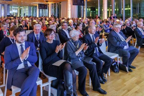 Erste Reihe beim VdK-Festakt. Dort sitzen nebeneinander Felix Banaszak (Bündnis 90/DIE GRÜNEN), Bettina Stark-Watzinger (FDP), VdK-Ehrenpräsidentin Ulrike Mascher, Bundeskanzler Olaf Scholz und Karl-Josef Laumann (CDU)