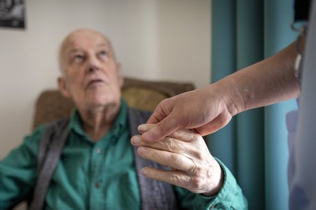 Hand hält die Hand eines älteren Mannes