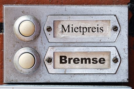 Klingelschilder an einem Mietshaus, statt Namen stehen in den Klingelschildern die Worte "Mietpreis" und "Bremse."