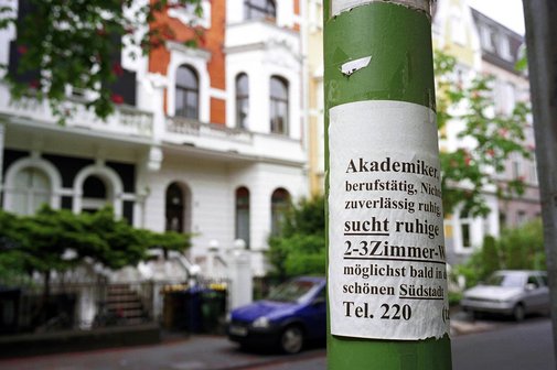 Wohnungssuche Zettel mit einem Wohnungsgesuch und Abreißzetteln mit der Telefonnummer des Interessenten an einem Laternenmast