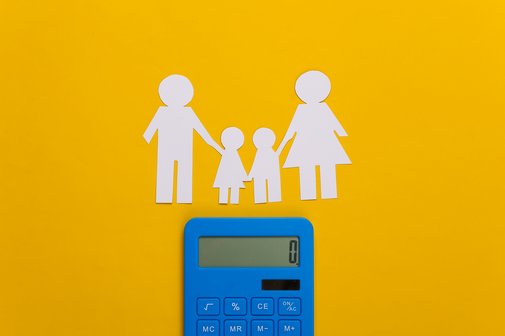 Elterngeld Ein blauer Taschenrechner und Scherenschnitt einer Familie mit zwei Kindern auf gelben Hintergrund