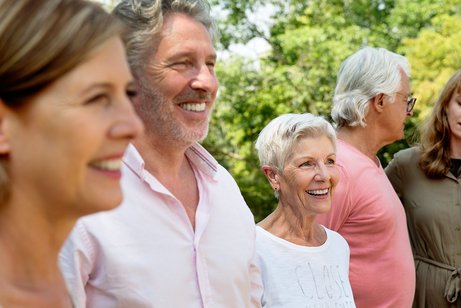 Gruppe gut gelaunt Mehrere Männer und Frauen sind gut gelaunt, lachen. Sie sind draußen im Grünen.