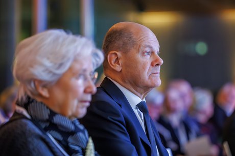 Ulrike Mascher und Olaf Scholz sitzen beim VdK-Festakt nebeneinander und hören bei einer Rede zu.