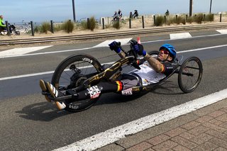 Para-Radsportler Manuel Scheichl fährt mit seinem Handbike auf einer asphaltierten Straße.