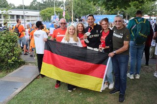 Michael Teuber mit seiner Familie, die gemeinsam eine Deutschland-Flagge in den Händen hält. 