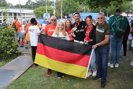 Michael Teuber mit seiner Familie, die gemeinsam eine Deutschland-Flagge in den Händen hält. 