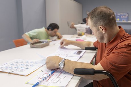 Werkstatt für Menschen mit Behinderung Mehrere Männer bei der Arbeit in einer Behindertenwerkstatt.