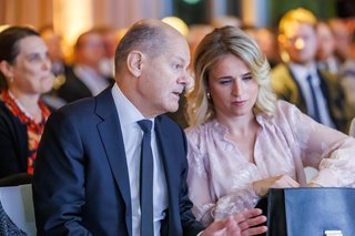 Bundeskanzler Olaf Scholz und VdK-Präsidentin Verena Bentele sitzen nebeneinander, unterhalten sich. 