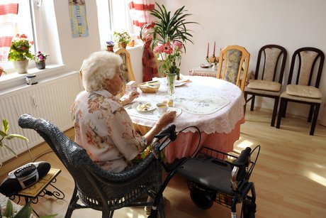 Eine Seniorin trinkt Kaffee in einem Altenheim. 