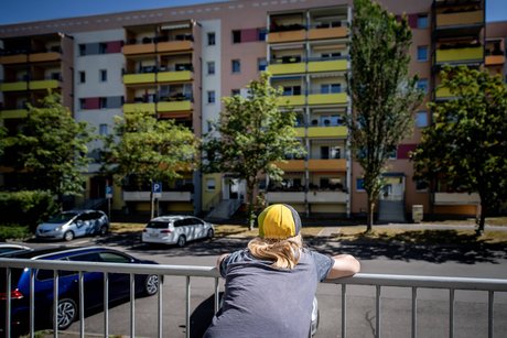 Ein Kind steht vor einem Plattenbau in Leipzig-Gruenau