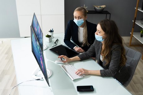 Auszubildende sitzen am Schreibtisch und arbeiten am Computer