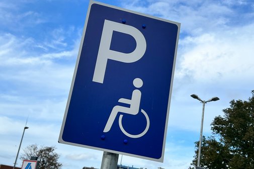 Ein Schild weist einen Behindertenparkplatz aus.